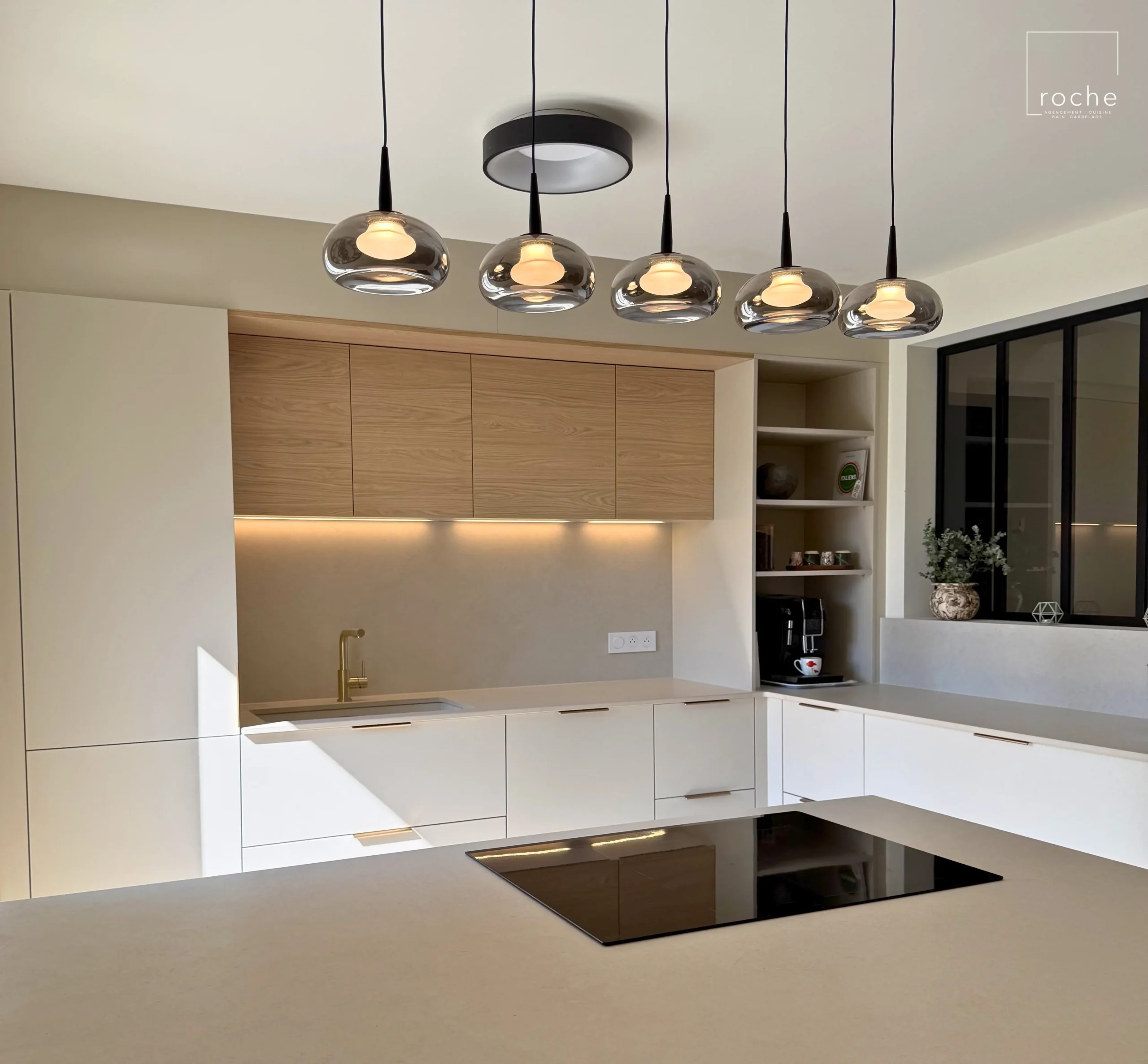 Cuisine contemporaine avec grand îlot blanc, suspensions et mobilier beige